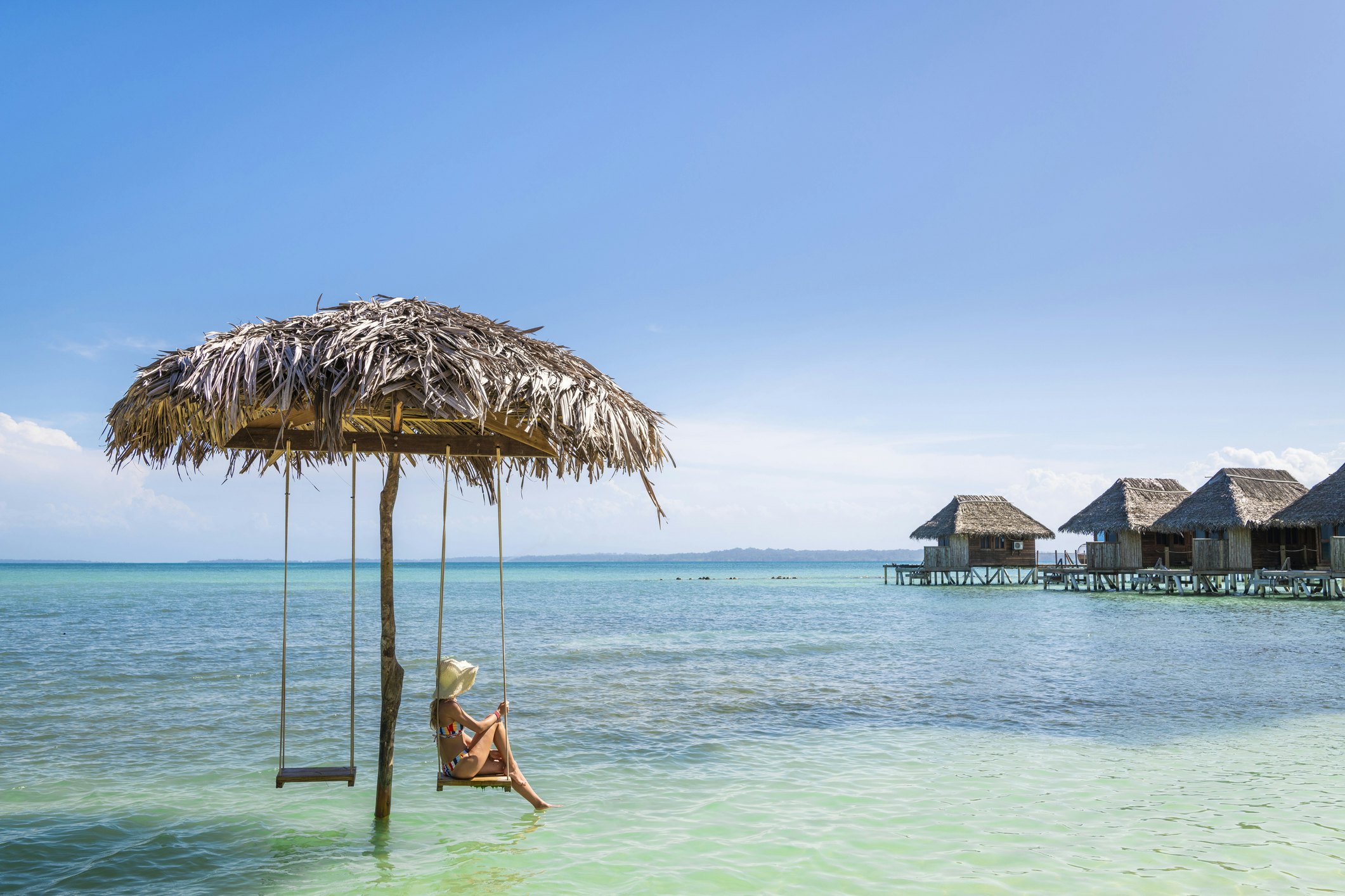 Turistas atsipalaiduoja ant sūpynės per vandenį Bocas del Toro mieste, Panamoje.