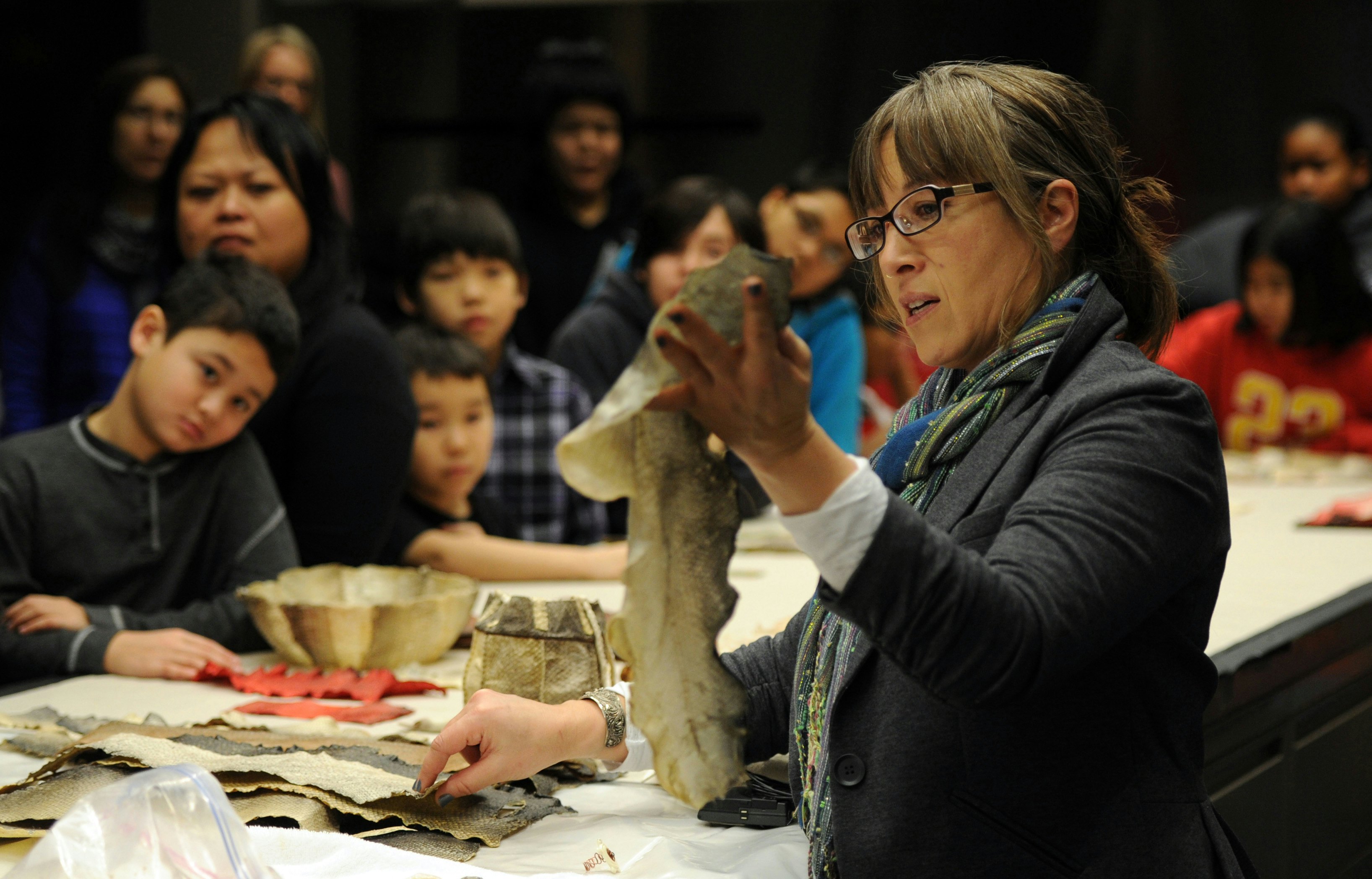 A woman holds a fish skin during a demonstration of Alaska Native practices in Anchorage, Alaska.