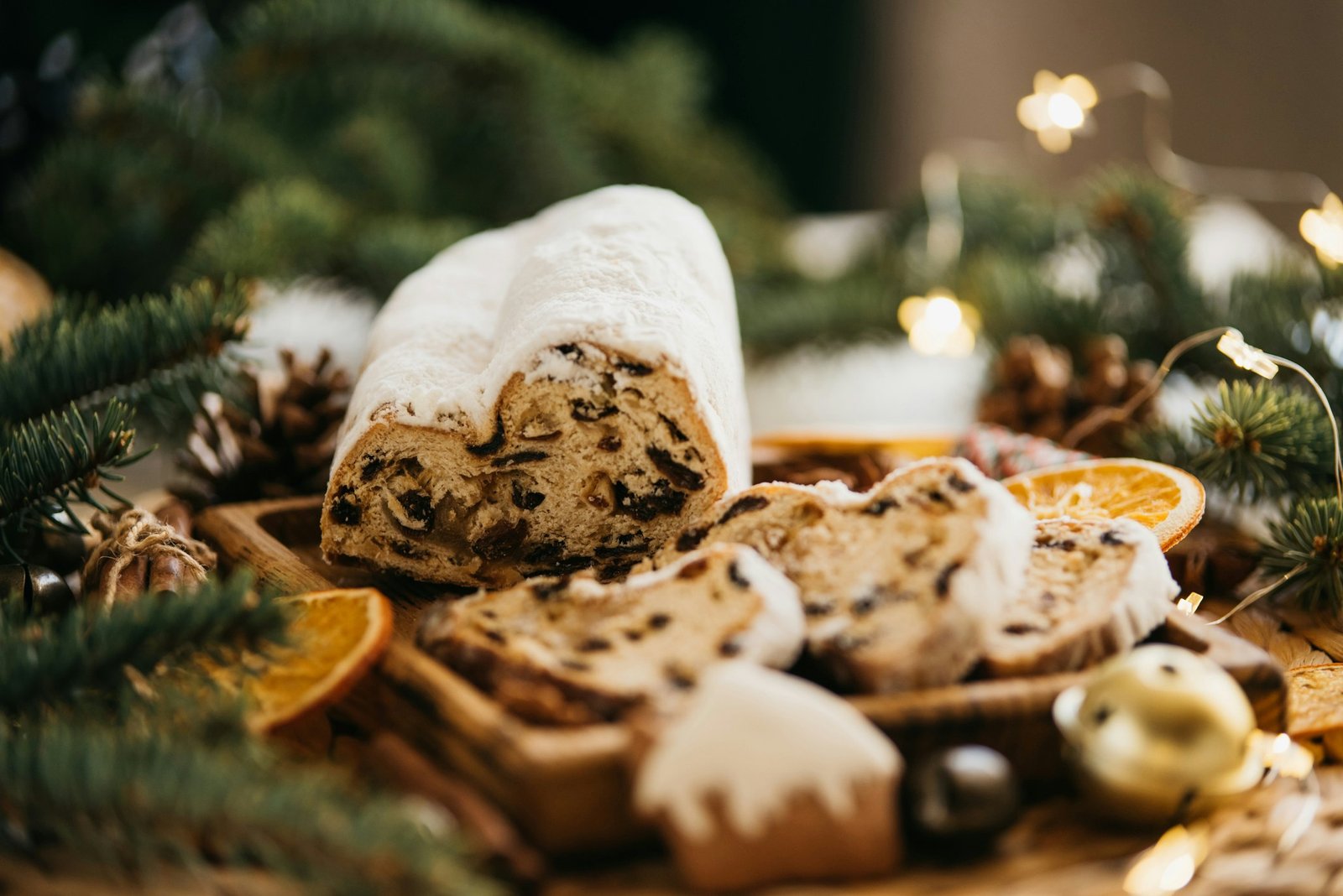 Kalėdos Stollen mediniame fone. Tradicinis kalėdinis vokiečių desertas supjaustytas gabalėliais. Tortas su riešutais, razinomis su marzipanu ir džiovintais vaisiais ant pjaustymo lentos. Kepimas Kalėdoms