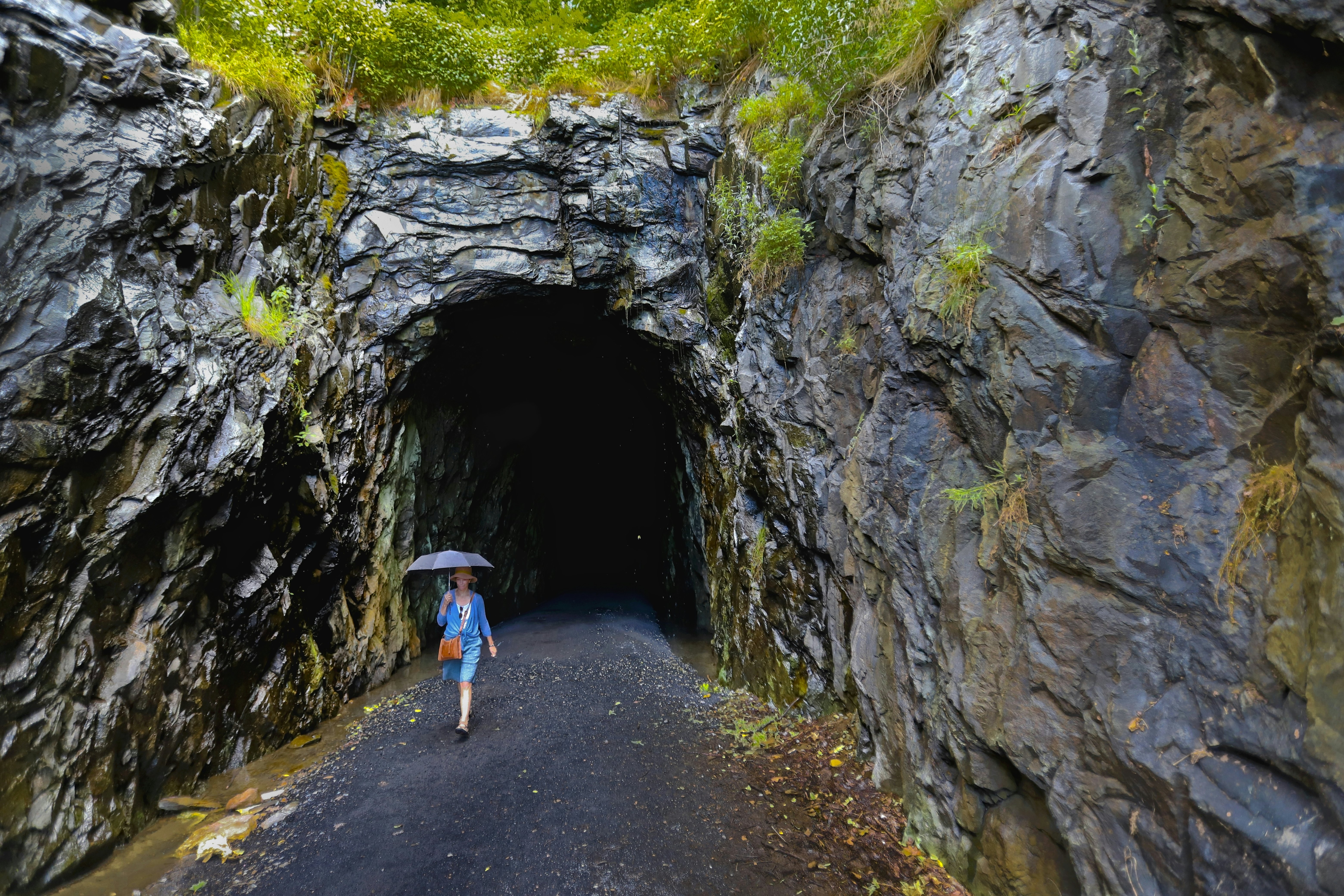 Moteris su skėčiu prie buvusio geležinkelio tunelio, šiuo metu Blue Ridge Tunnel East tako pradžia.