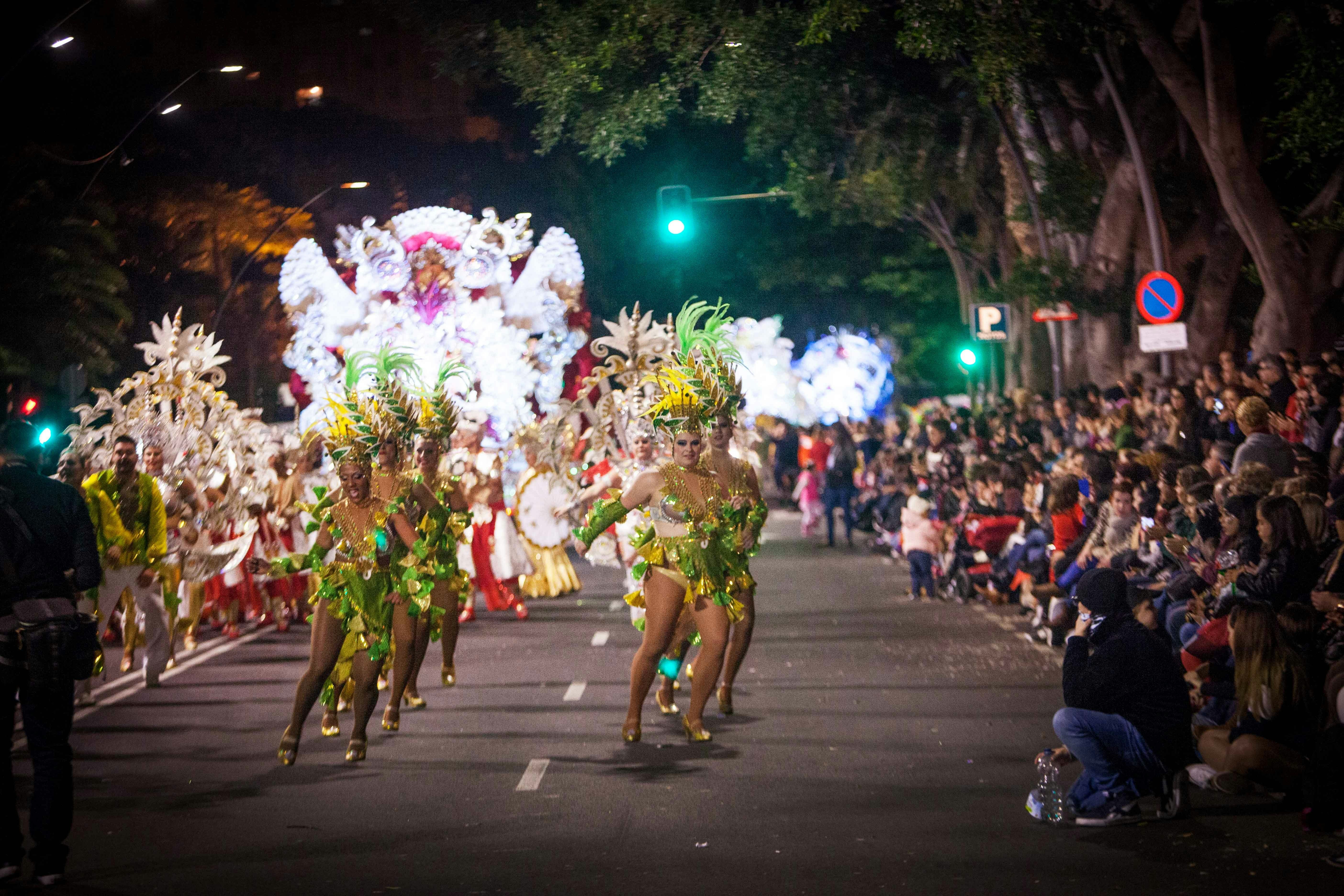 Šokėjai žvilgančiuose, plunksnuotuose kostiumuose, parade gatvėje, Carnaval mieste Santa Kruze, Ispanijos Kanarų saloje Tenerifėje