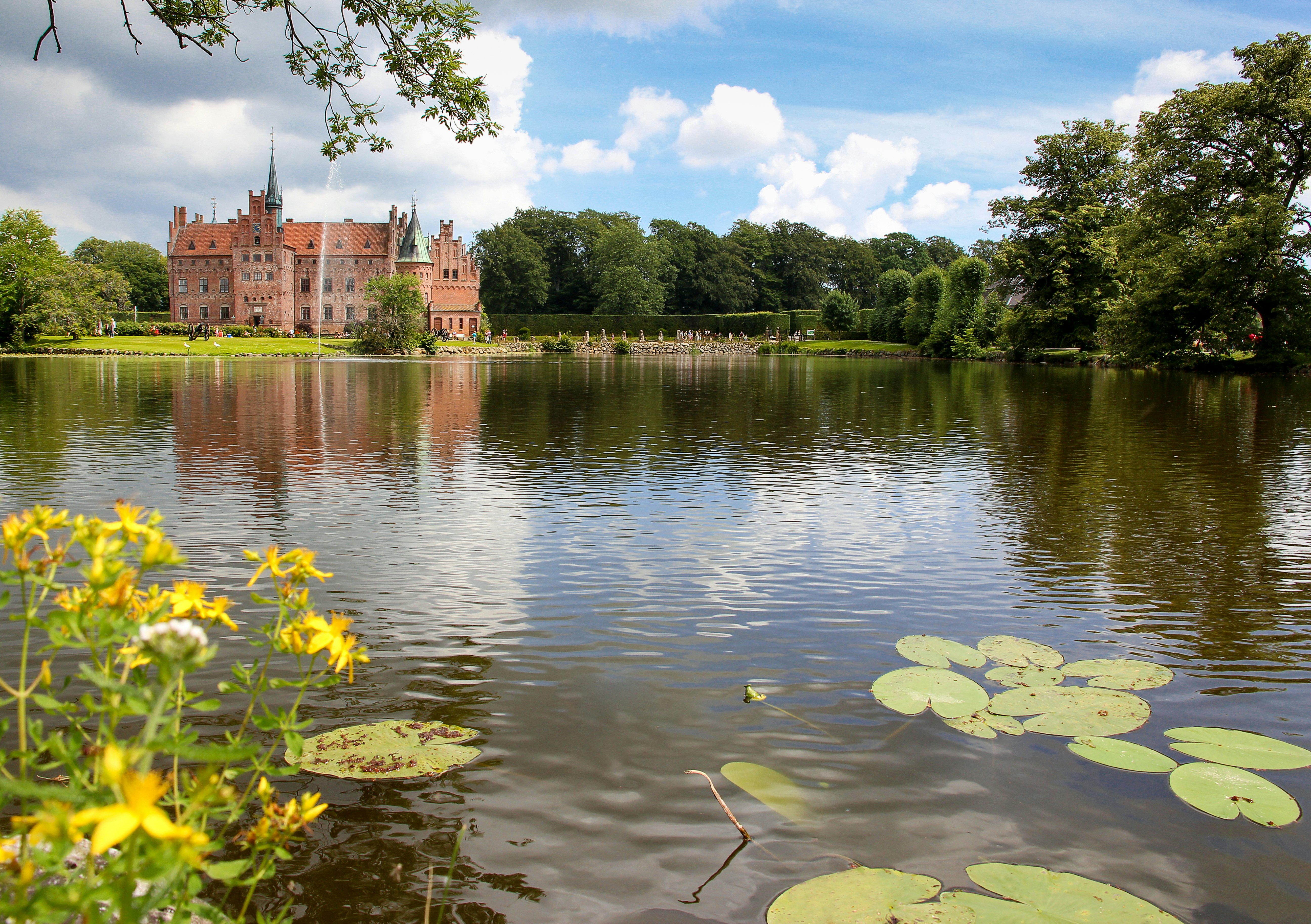 A red-brick castle beside a lake