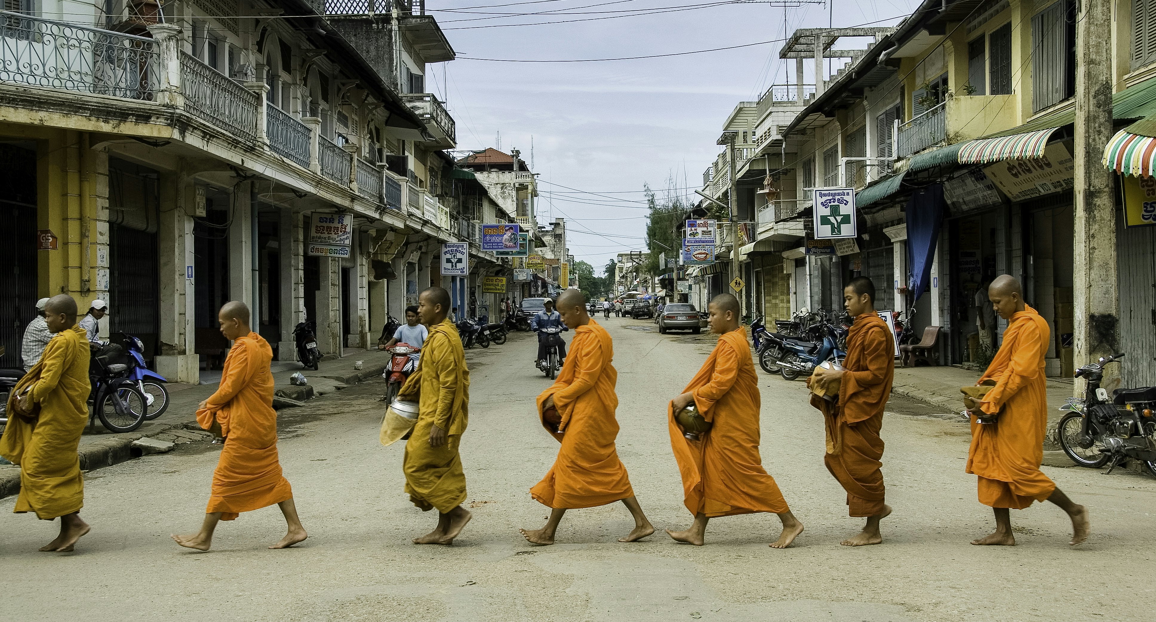 Vienuoliai vaikšto per miesto gatvę, panašiai kaip Luang Prabang