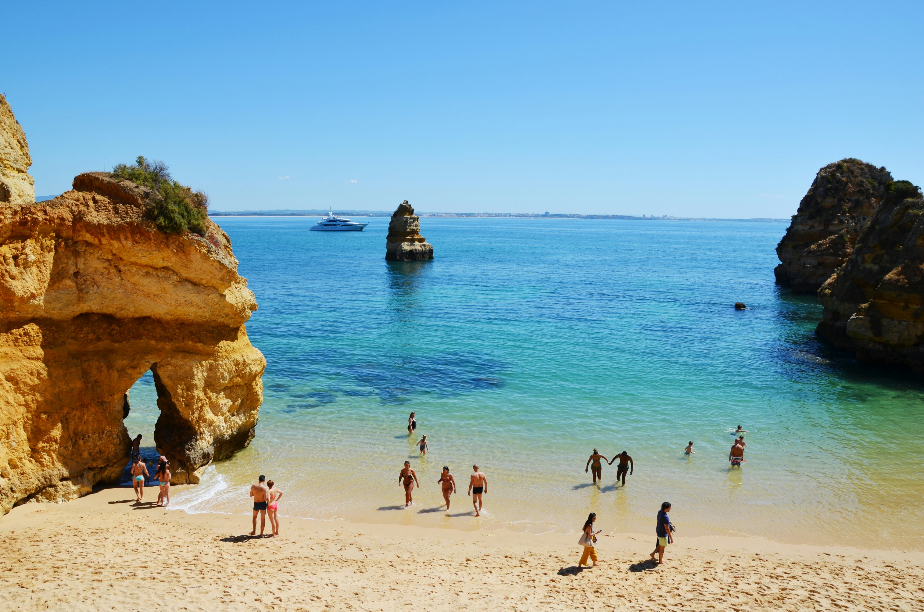 Žmonės į vandenį viliojo vaizdingame Camilo paplūdimyje („Praia do Camilo“) Algarvėje, Portugalijoje, Europoje