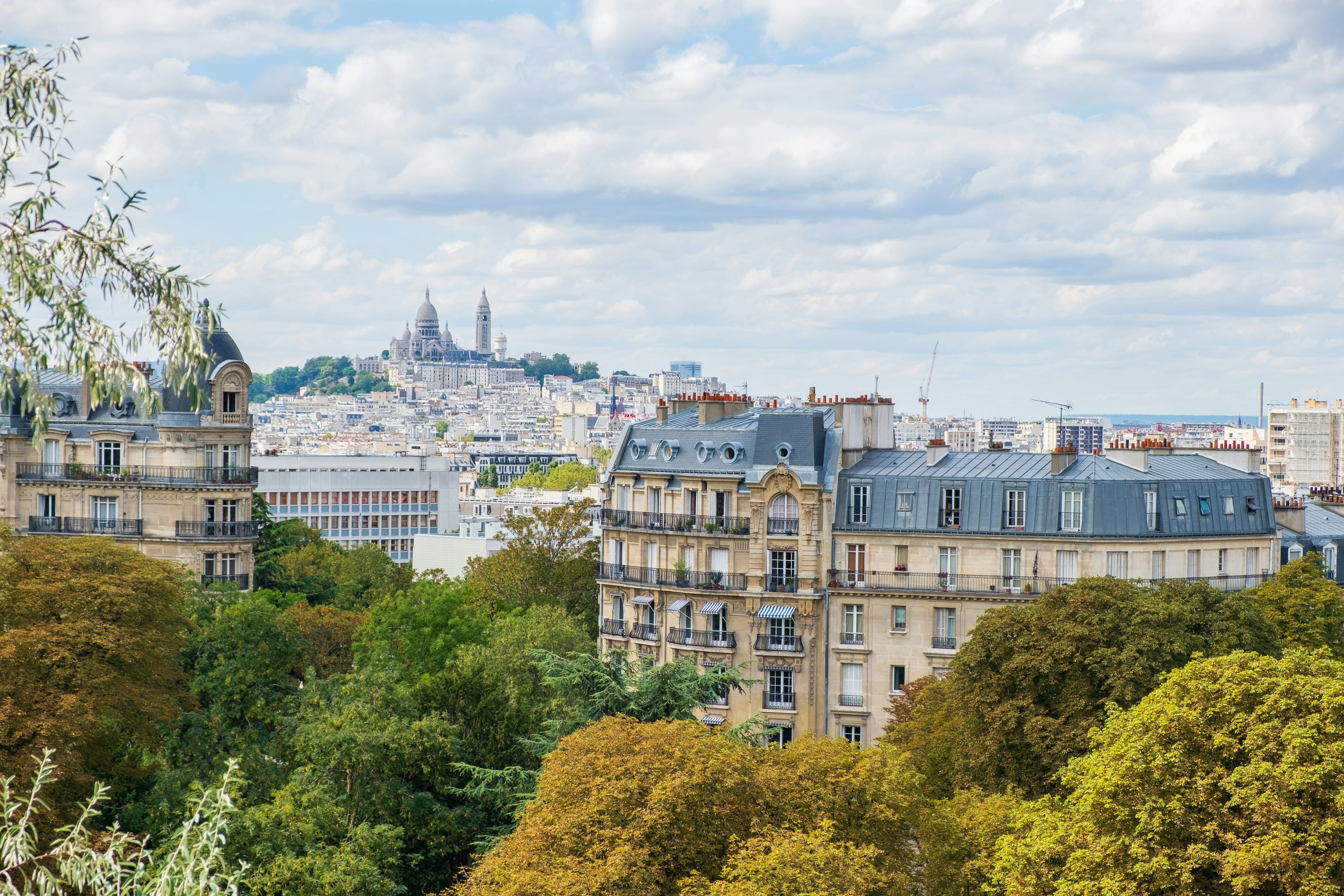 Paryžiaus panorama su Montmartre Hill ir Sacre Coeur Basilica, peržiūrėta iš Buttes-Chaumont parko.