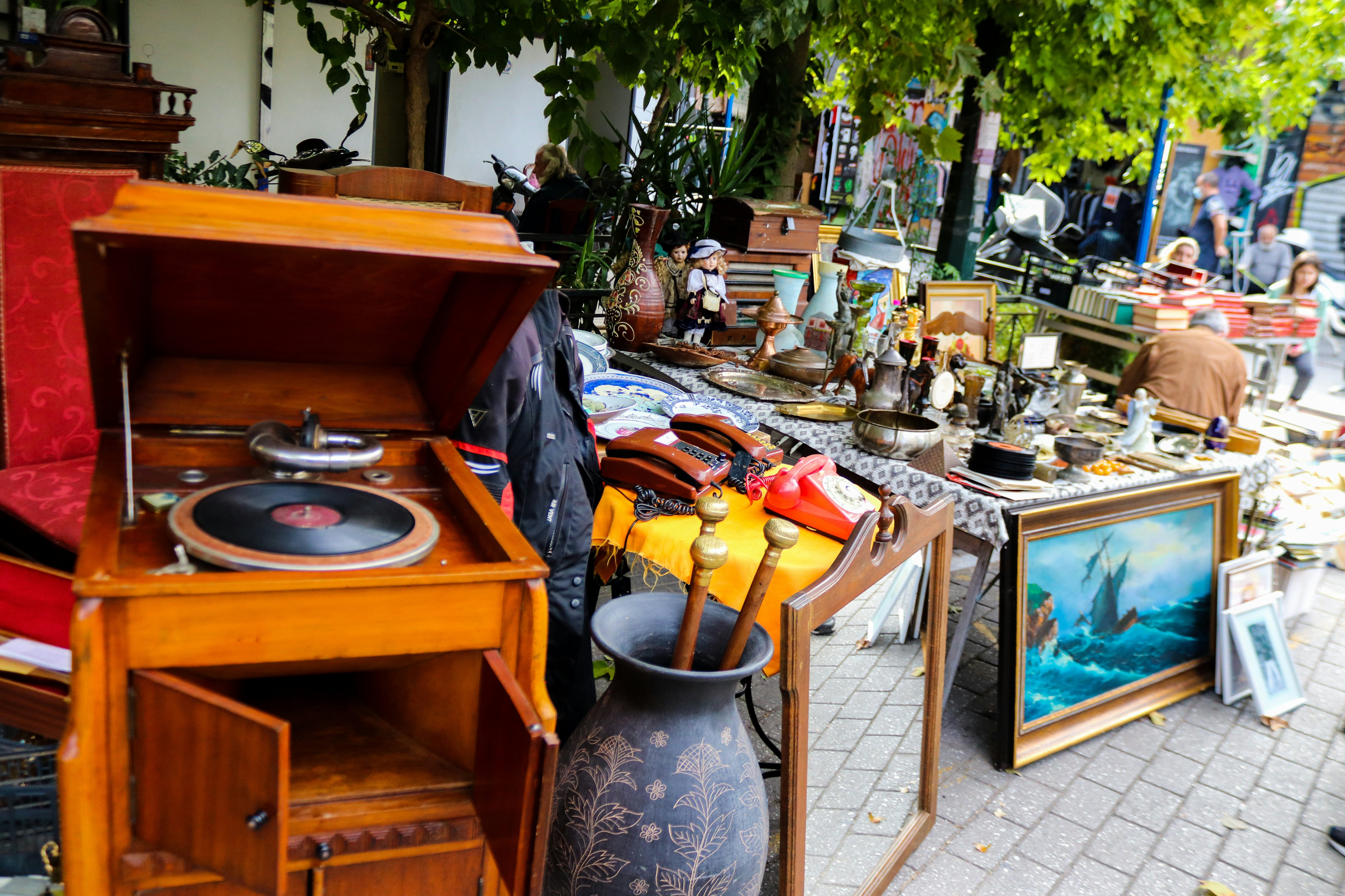 Vazos, įrašų grotuvas, paveikslai ir generolas BRIC-A-BRAC rodomas ant grindinio sendaikčių turguje