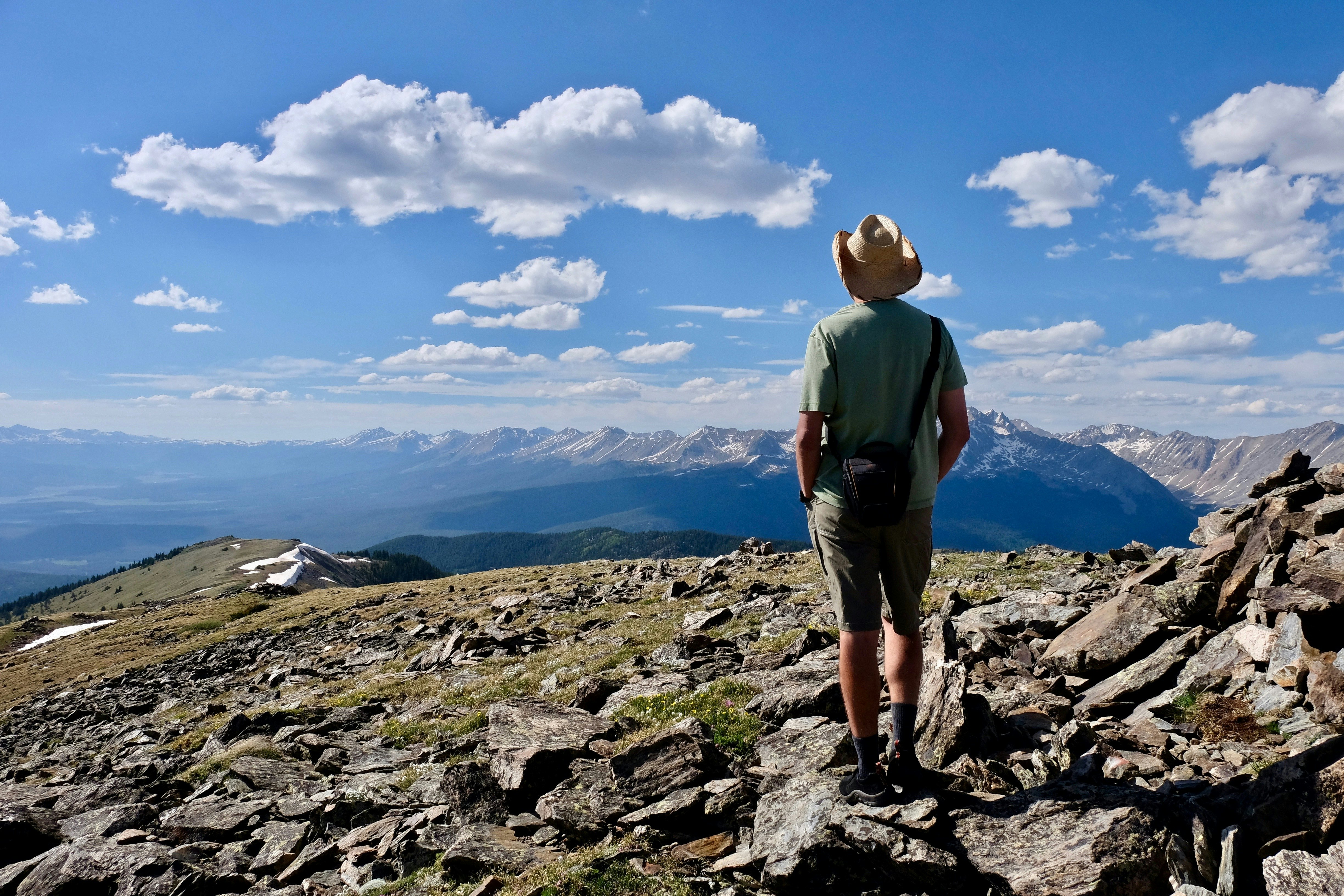 A man in a cowboy hat pausing to admire the views above Aspen, Colorado