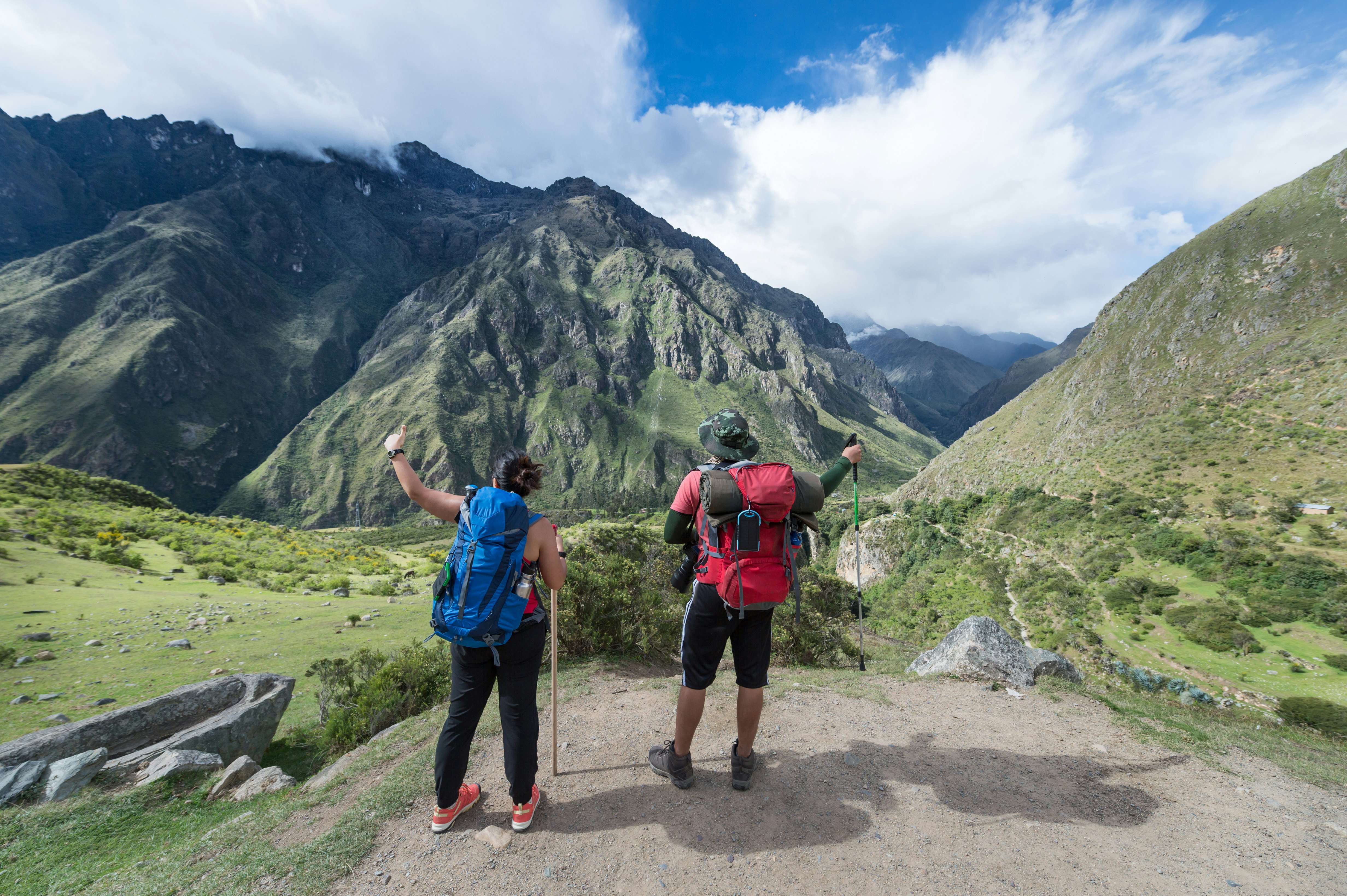 Du keliautojai žiūri į Machu Picchu.