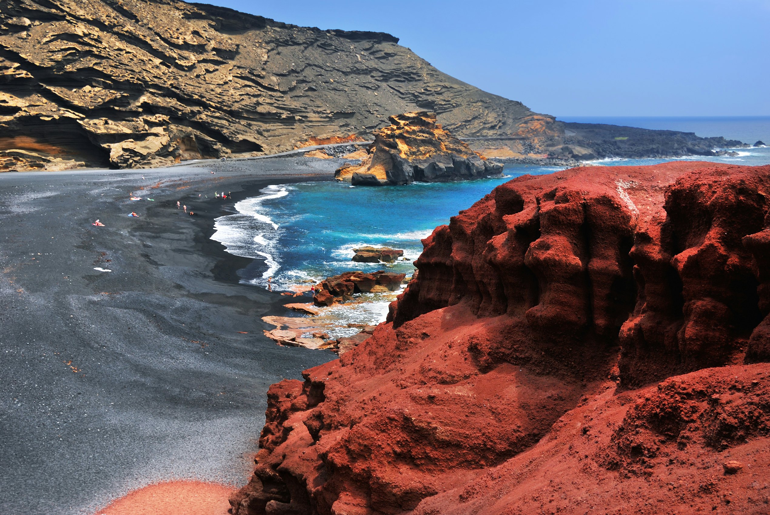 Lanzarote, black sandy beach in gulf of El Golfo, Atlantic ocean near Lago de los Clicos in Canary Islands.