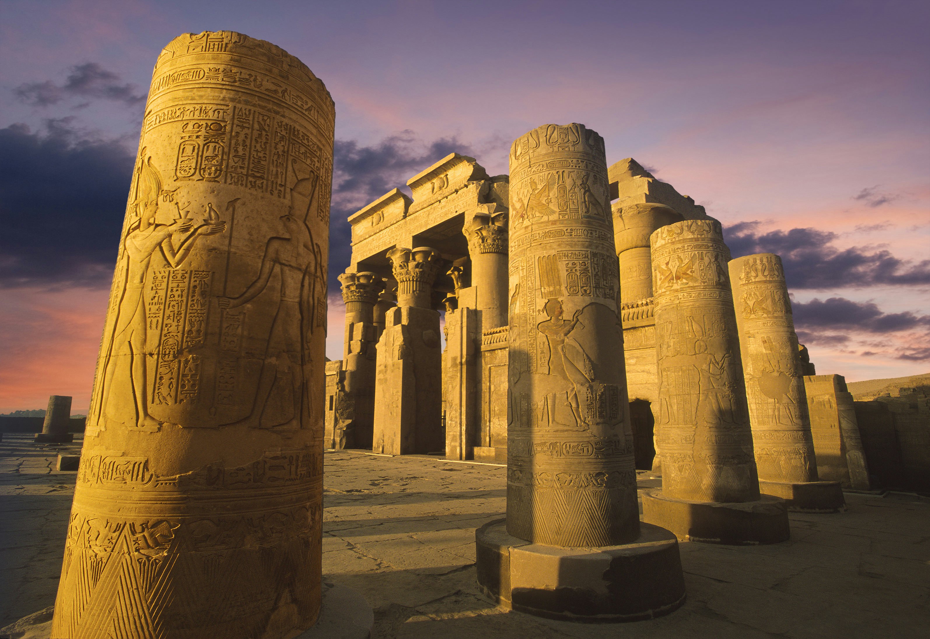 Egipto šventykla su didelėmis akmens kolonomis, padengtomis ofortomis, ir hieroglifai, apšviesti vakare, kai saulė leidžiasi