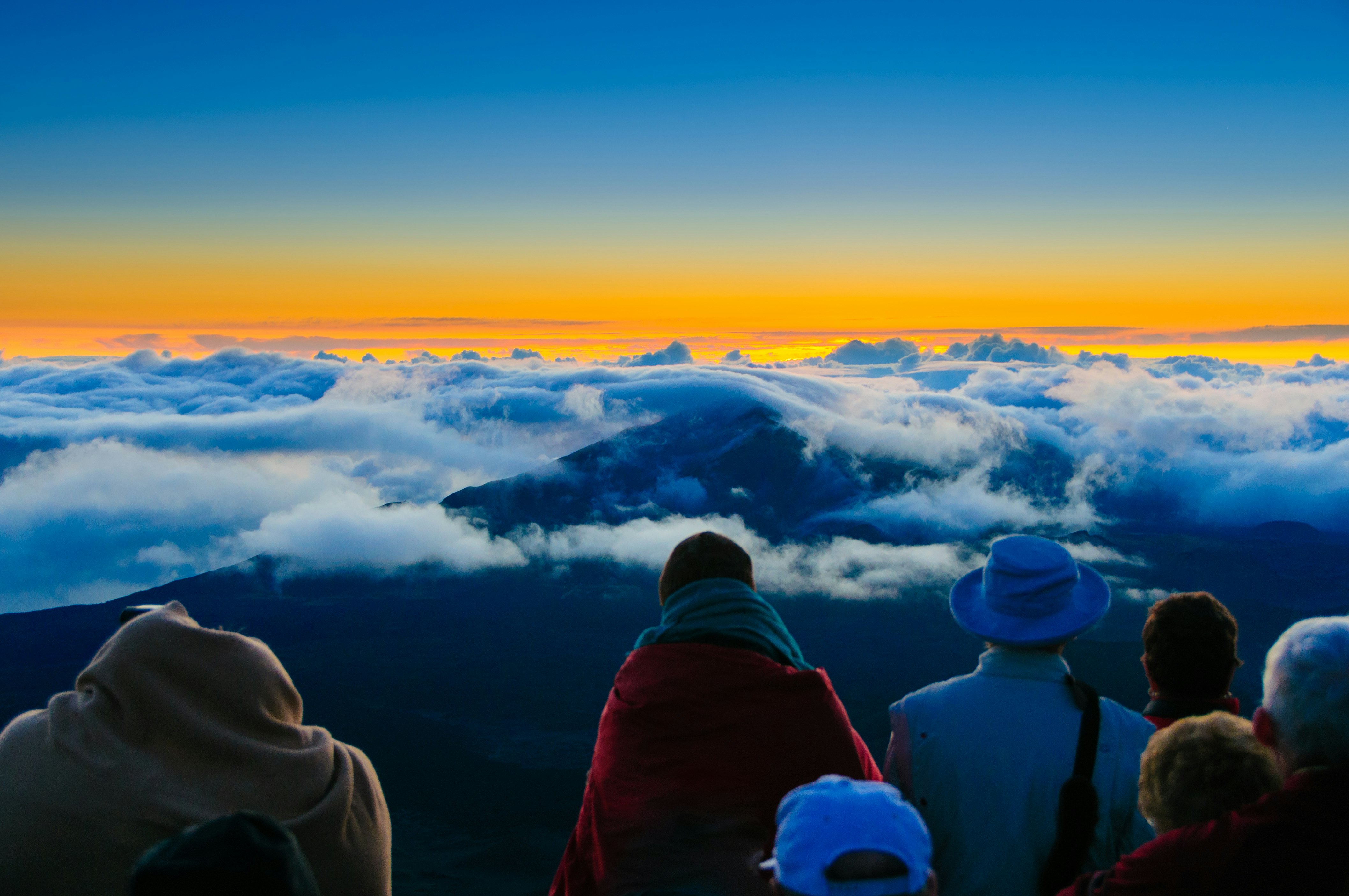 Saulėtekis virš debesų ir tolimų kalnų nuo Haleakala kraterio, Maui, Havajai, JAV