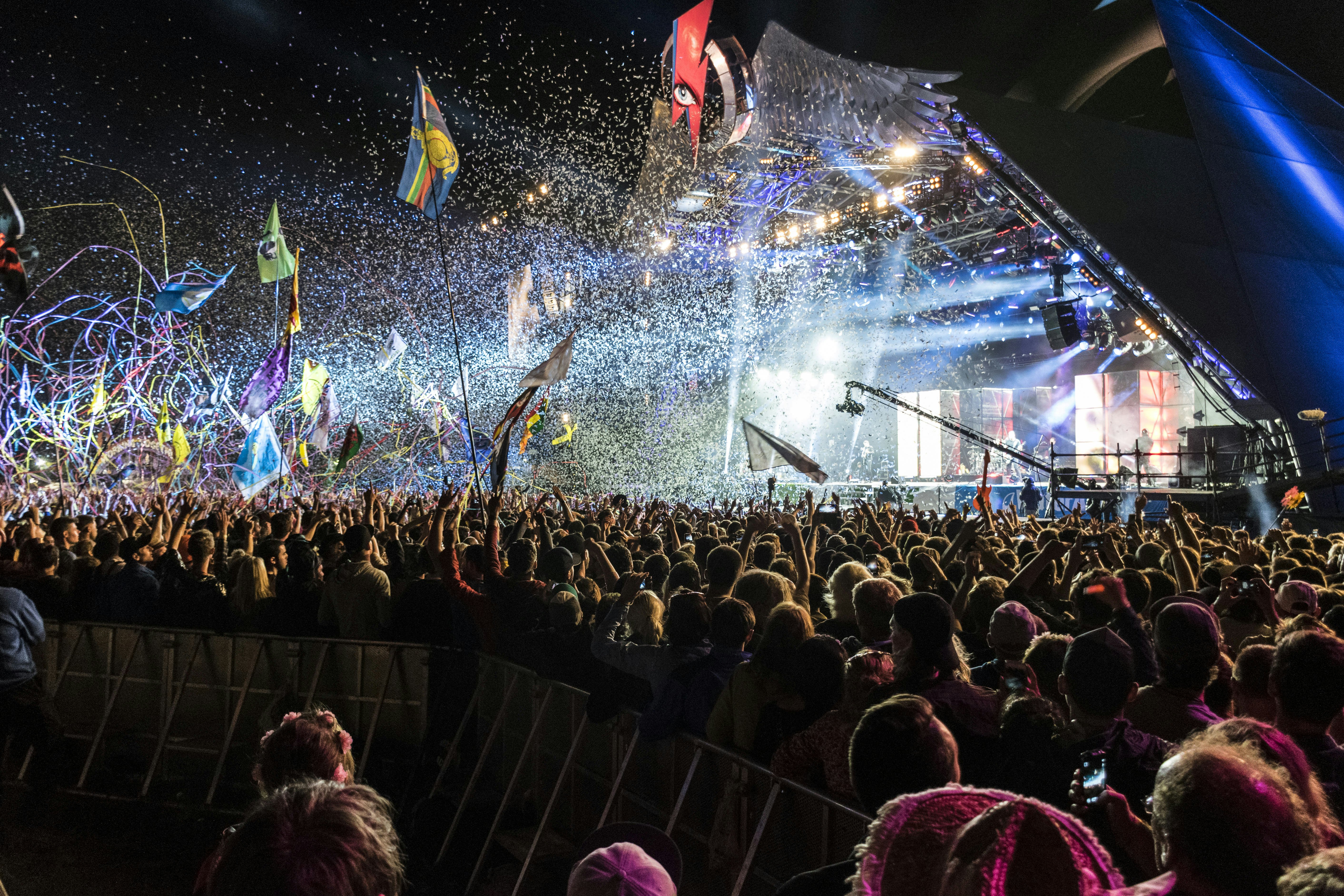 Konfeti, juostos ir šviesos sprogimas iš piramidės formos scenos Glastonberio festivalyje.
