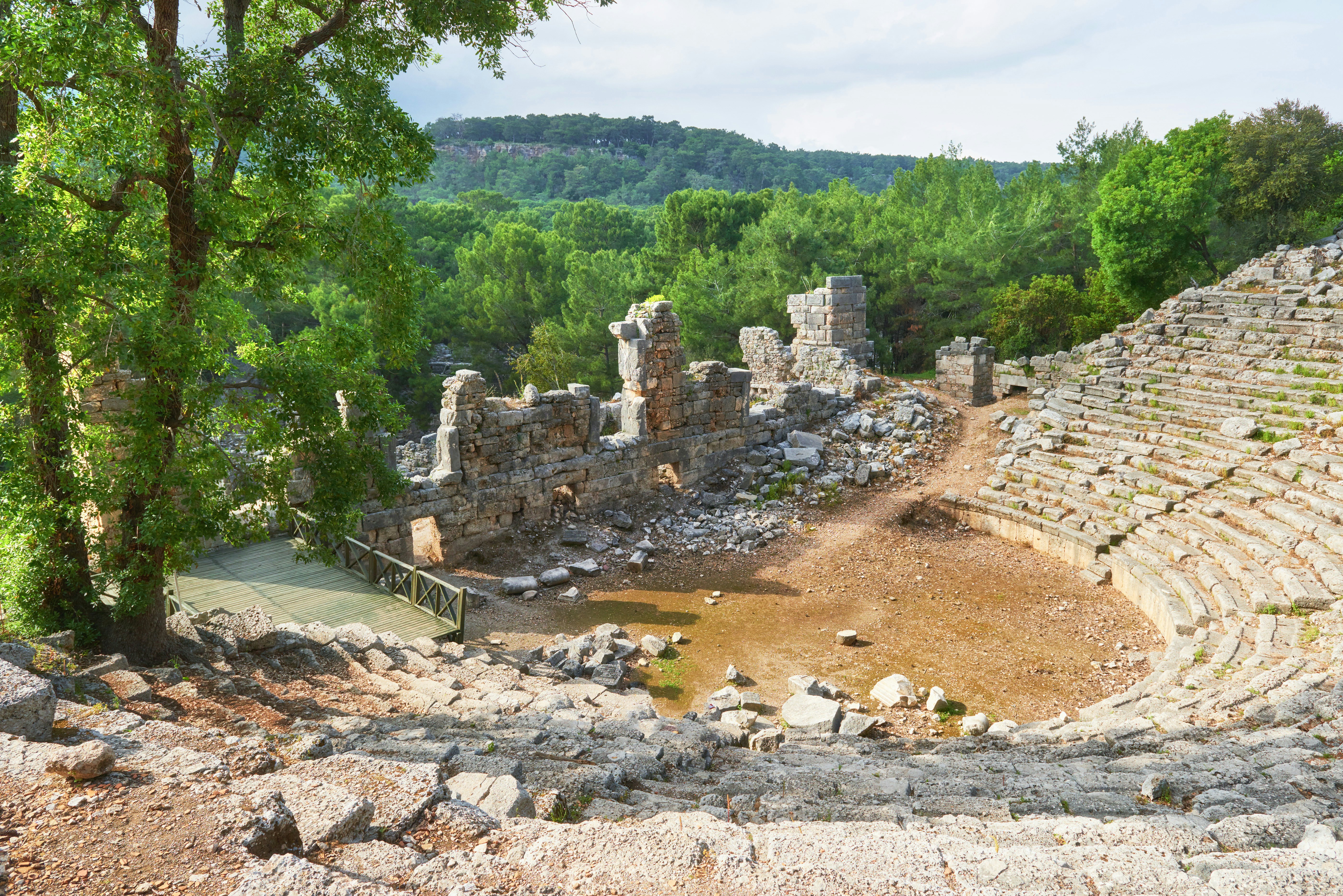 Pusiau valdomas amfiteatras, nukreiptas į griūvančią akmeninę sieną prie Trojos Turkijoje.