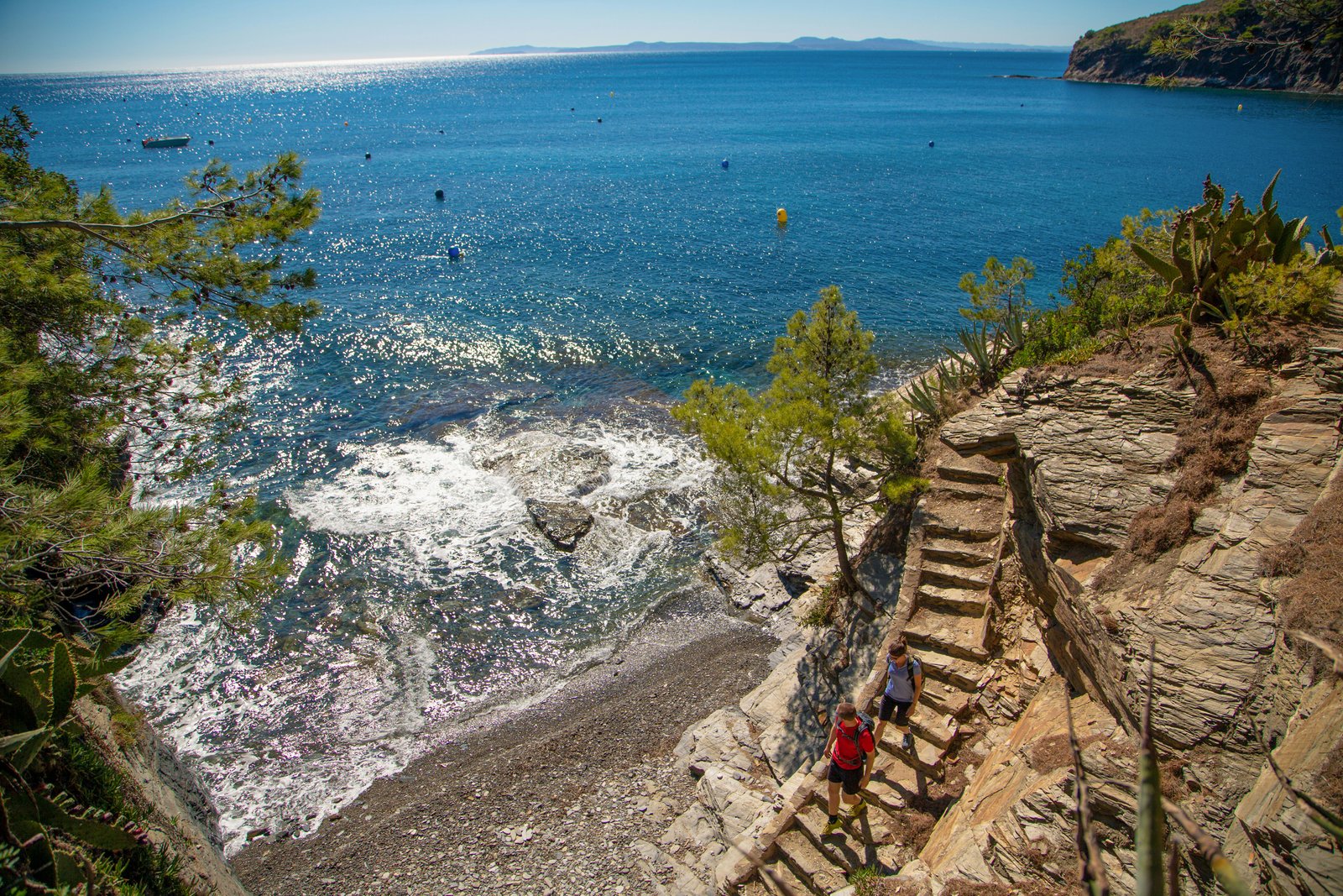 Vaizdas iš viršaus į žygeivius, žengiančius laiptais link nuošalaus paplūdimio, Cami de Ronda, Costa Brava