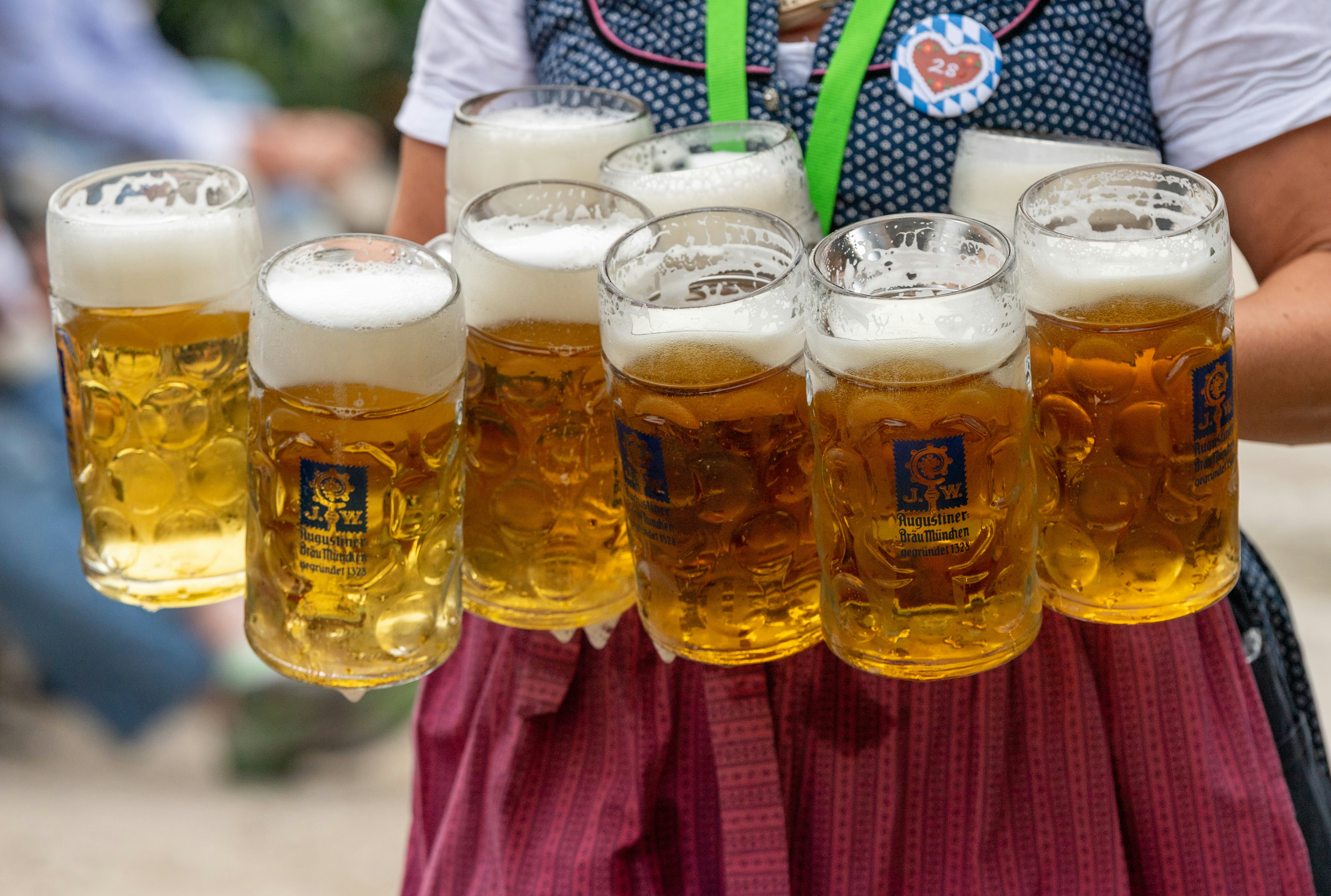 Padavėja neša devynis bokalus alaus prie stalų Dachau Volksfest šventėje, Bavarijoje.