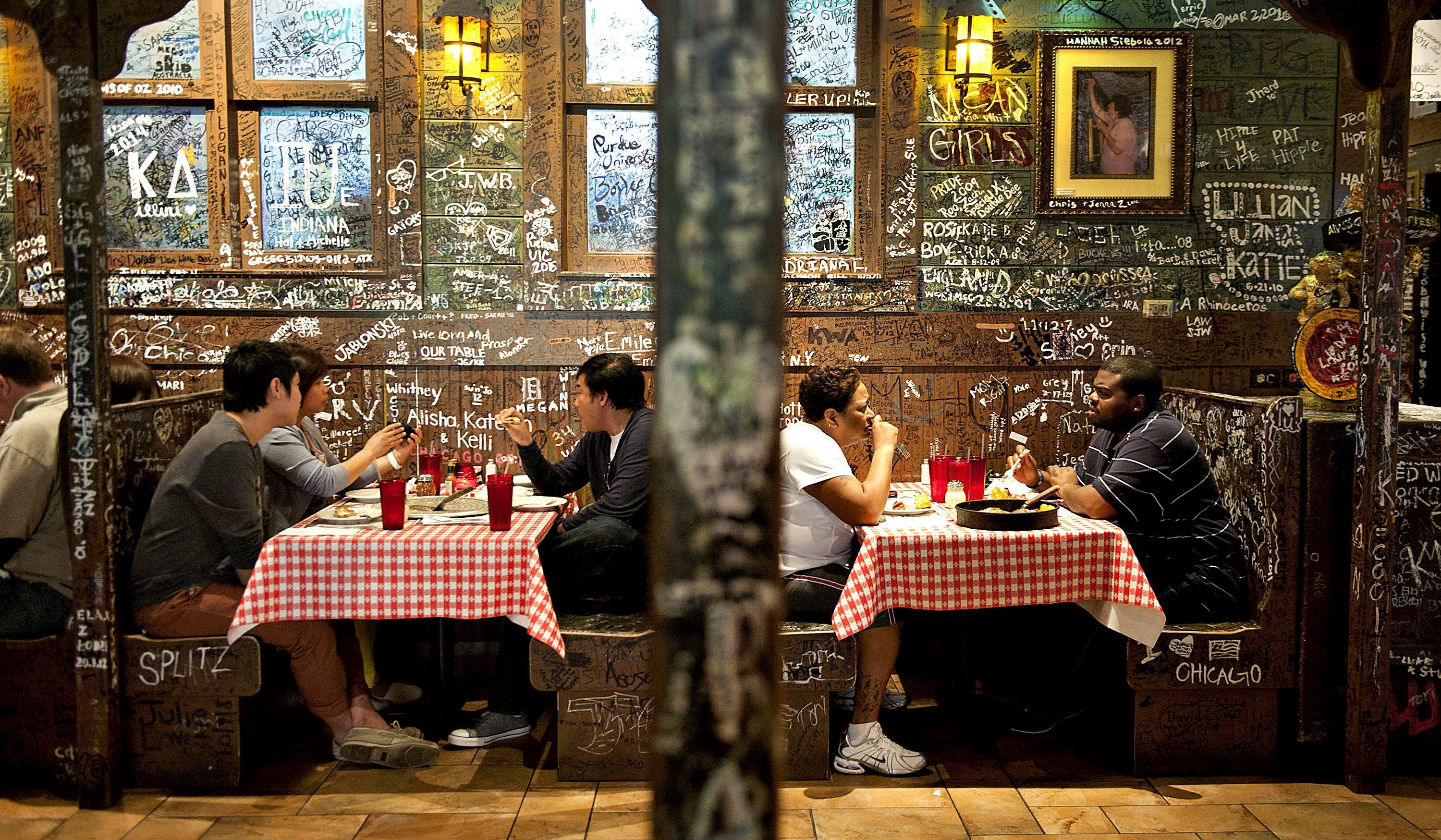 Klientai sėdi Gino's East restorane Čikagoje.