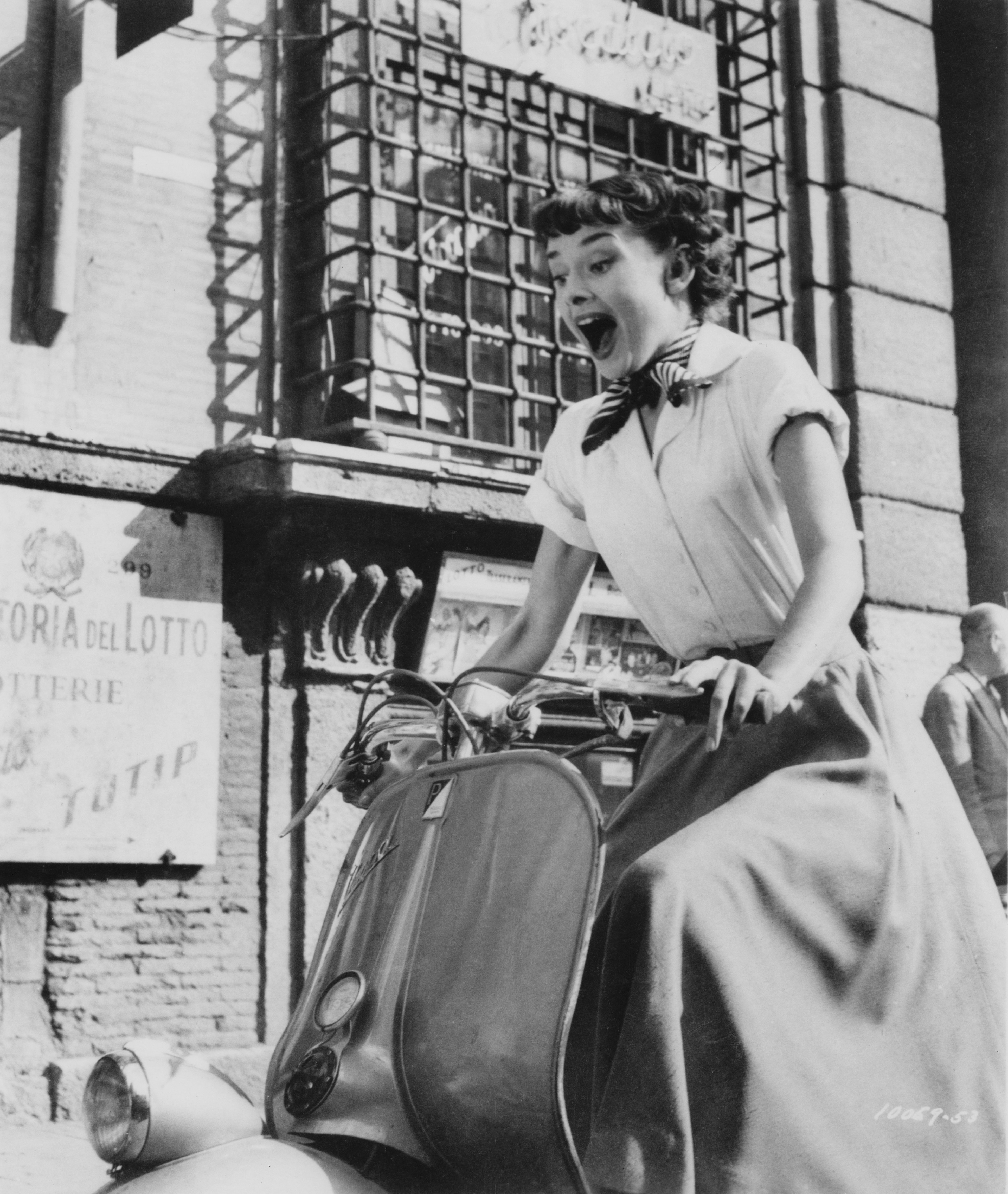 Belgijos kilmės aktorė Audrey Hepburn važiuoja motoroleriu per Romą filme „Roman Holiday“