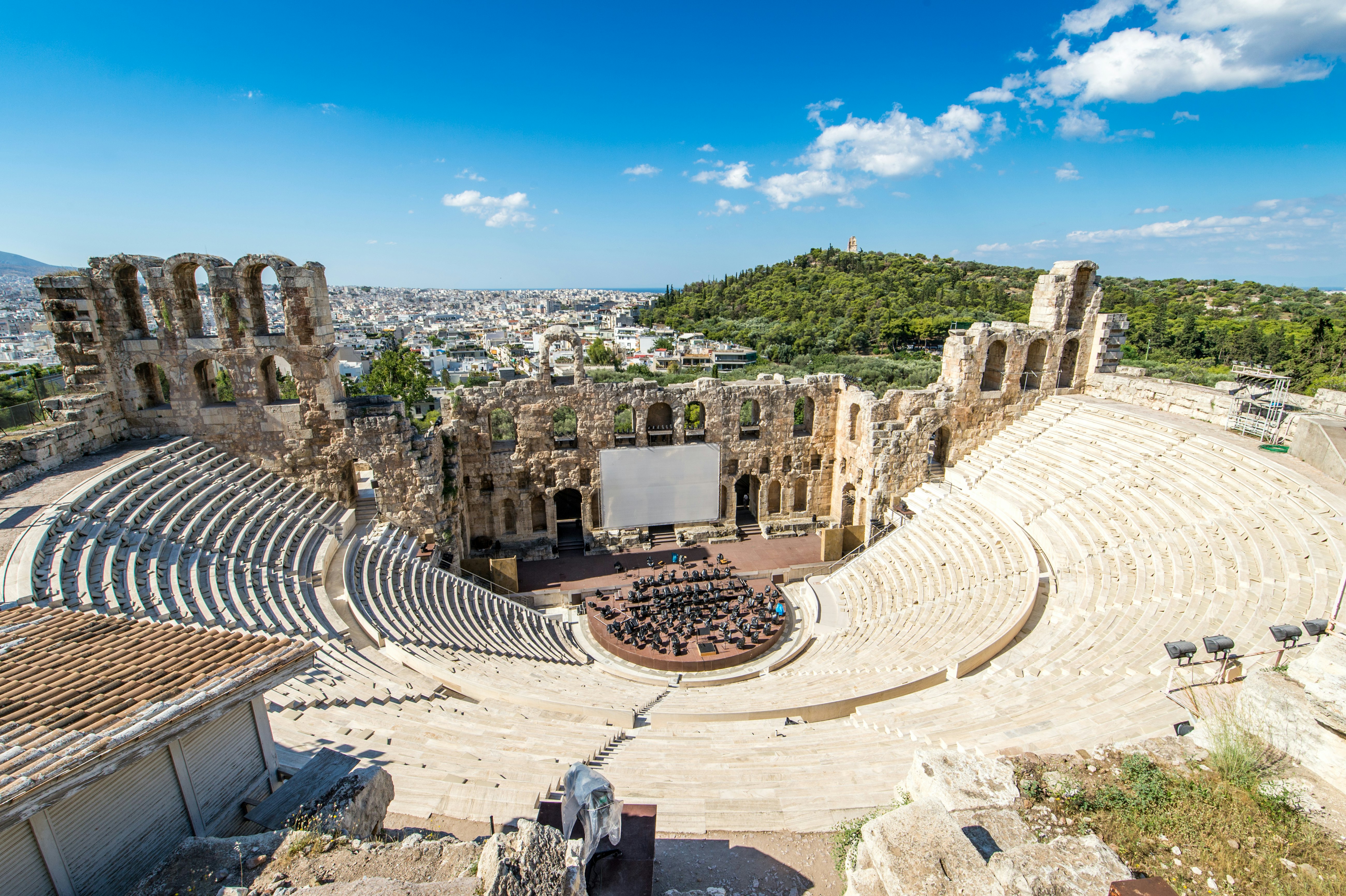 A vast ancient theater with seats surrounding a central stage
