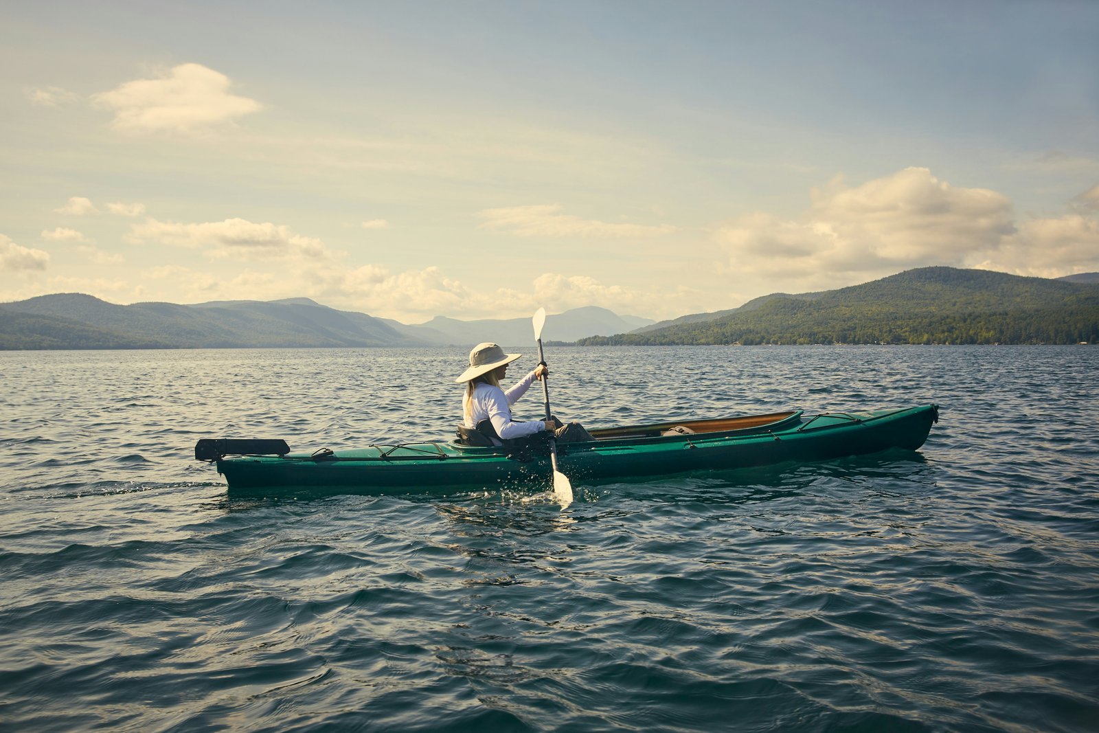 Moteris didelėje kanojoje slysta per Lake George.