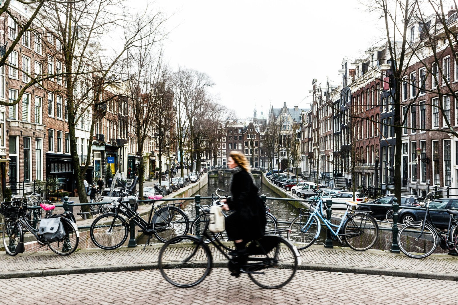 Dviratininkas, važiuojantis per tiltą Amsterdame.