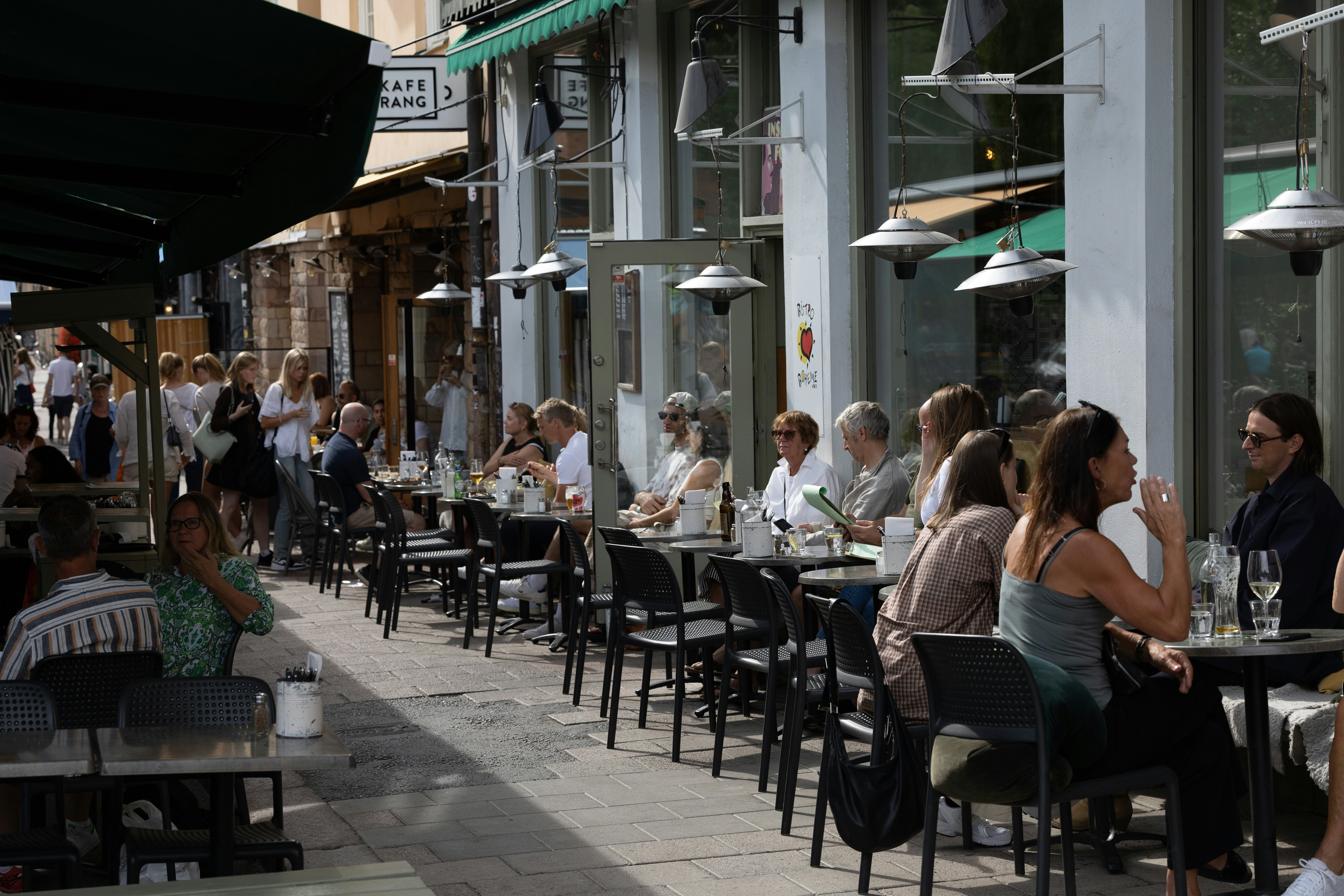 Žmonės sėdi lauko restorane ant Nytorget, Södermalm rajone, madingoje Stokholmo dalyje, Švedija