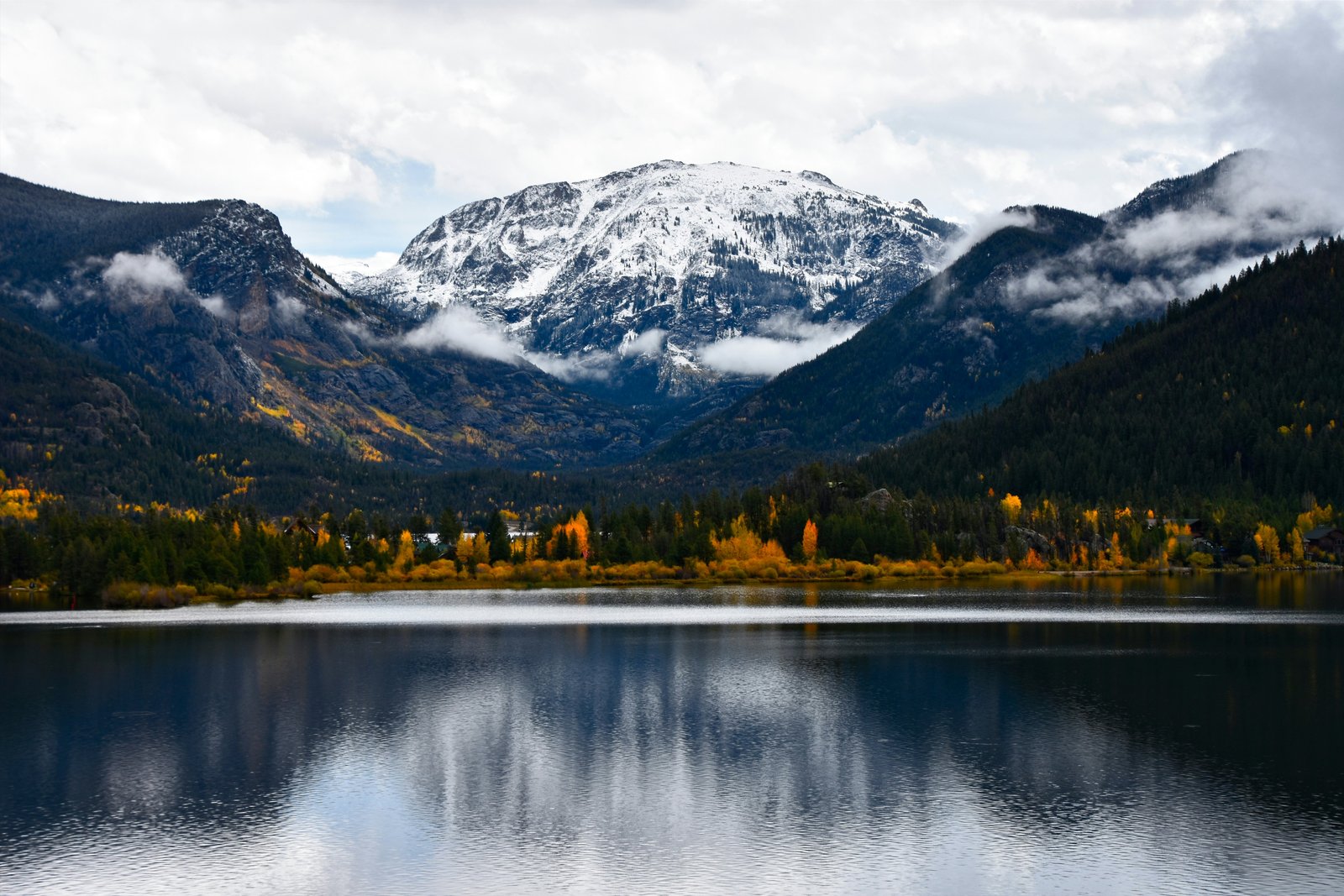 Kalno ir medžių atspindys ežere Rockies Kalnuose.