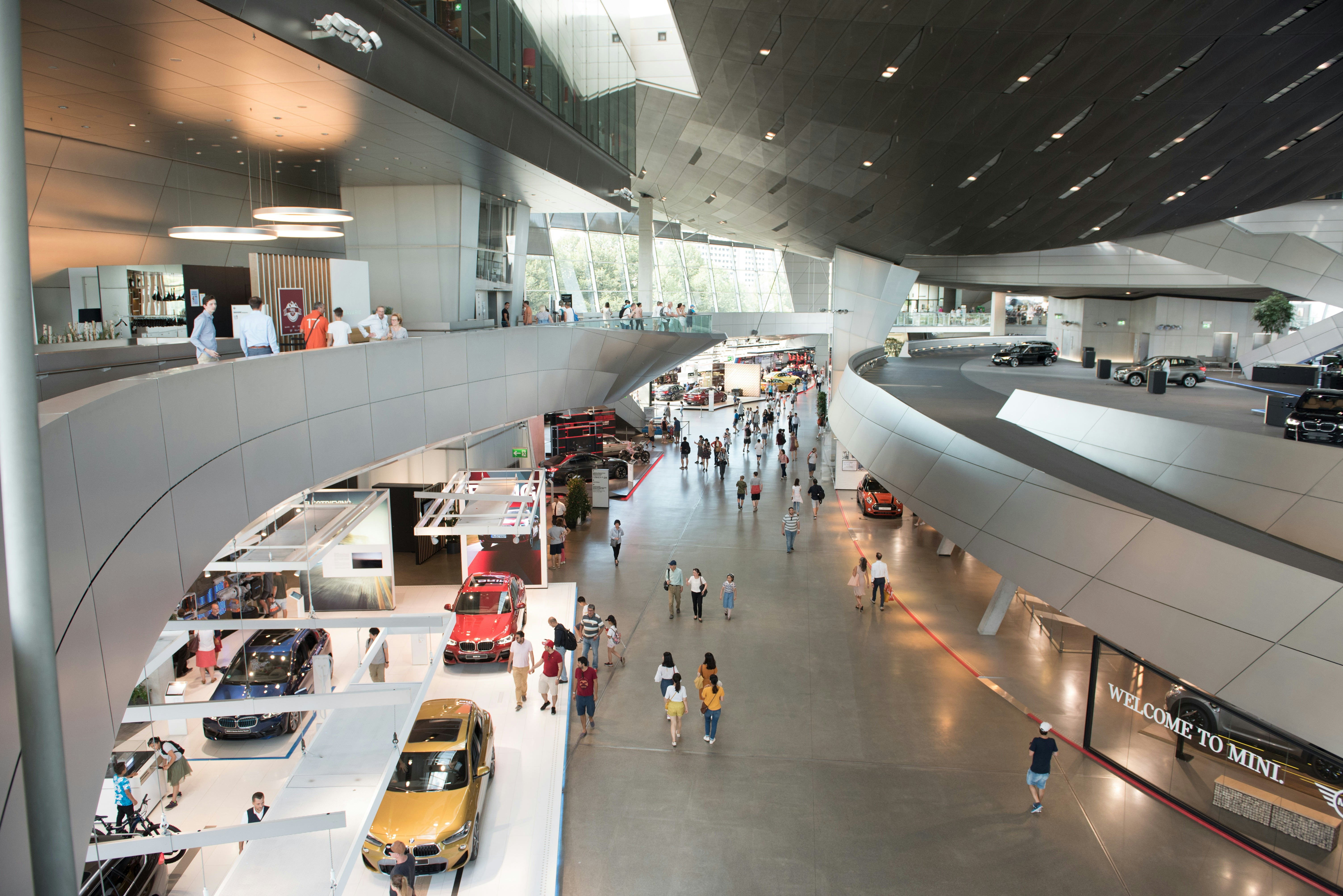 Lankytojai apžiūri automobilius BMW Welt galerijoje, Miunchene
