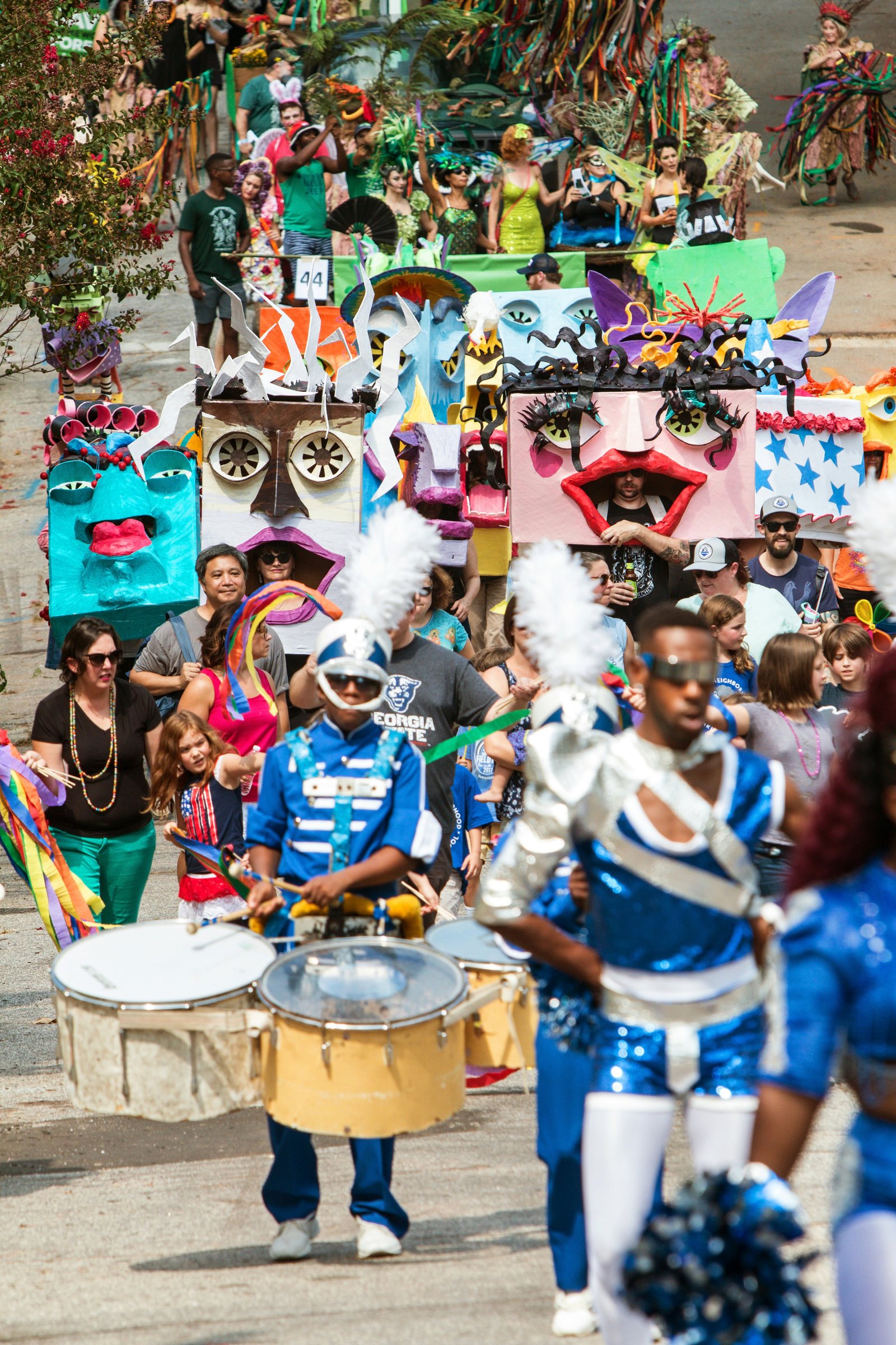 Didelė žmonių minia, dėvinti kaukes ir kostiumus, eisenoja East Atlanta Strut festivalyje