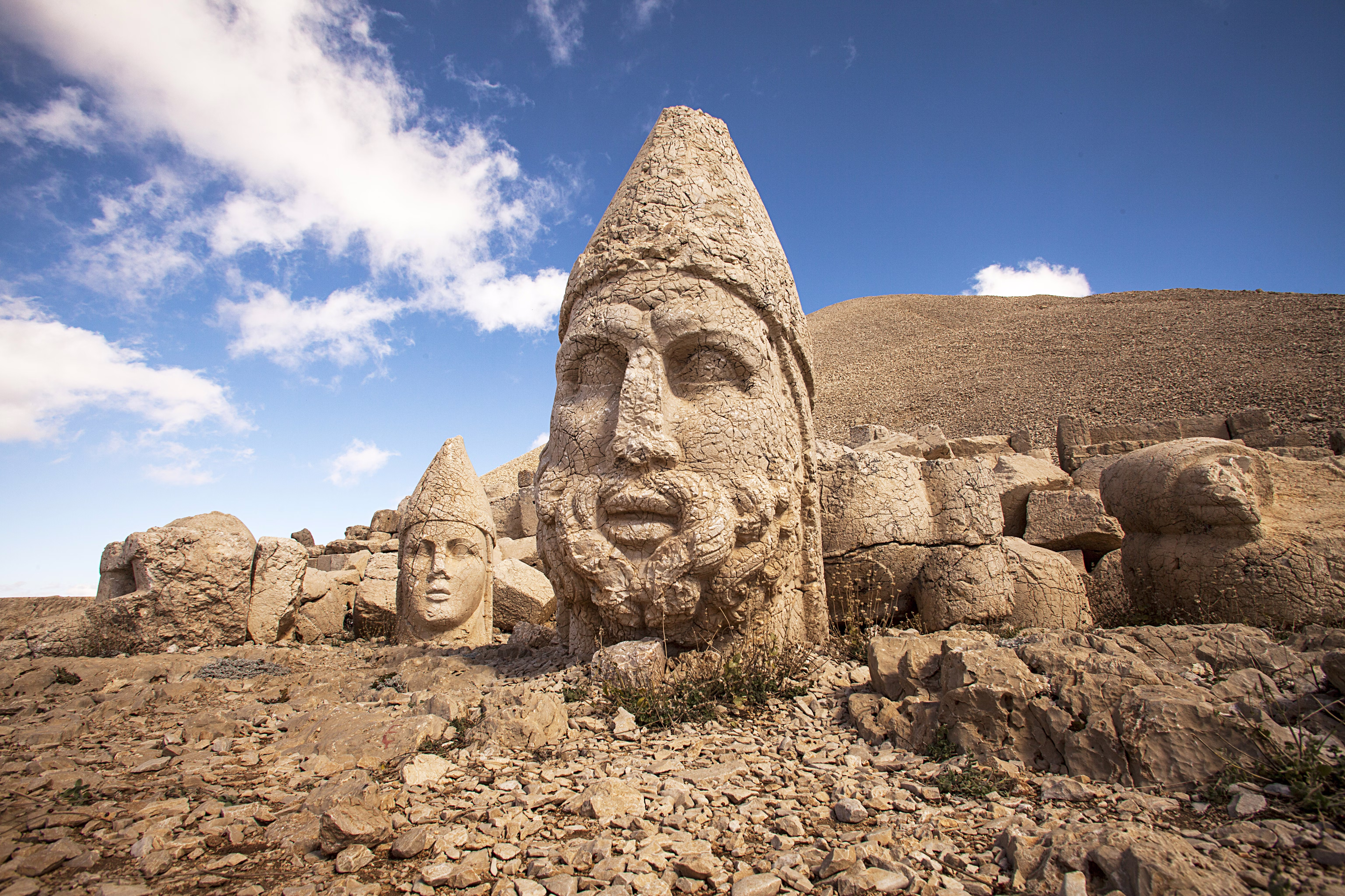 The heads of toppled statues in a dry, rocky landscape in Türkiye.