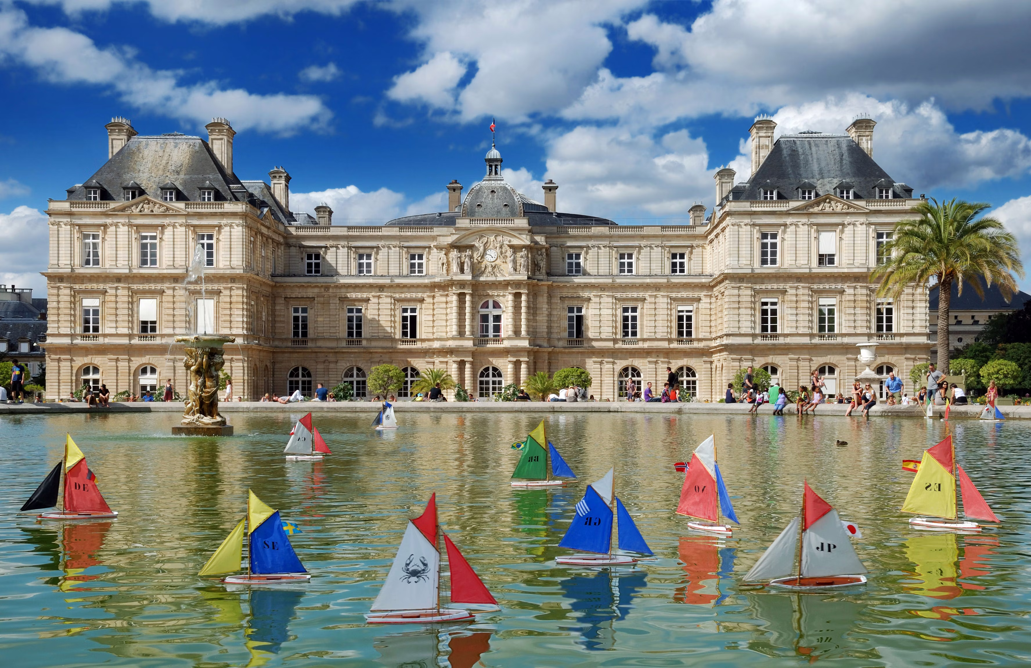 JULY 30, 2012: Model sailing boats in the pool in front of Luxembourg Palace in Luxembourg Gardens. 115372462 toy, ship, city, boat, palm, paris, basin, yacht, clock, france, statue, castle, palace, sights, famous, garden, senate, vessel, europe, history, chateau, chimney, antique, ancient, baroque, mansard, statuary, medieval, landmark, building, relaxing, historic, fountain, sculpture, antiquity, cityscape, bas-relief, luxembourg, recreation, relaxation, picturesque, architecture, entertainment, palais du luxembourg, jardin du luxembourg